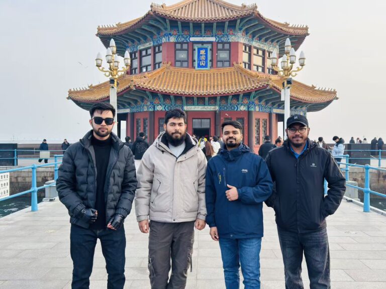 PrimeLink team at a traditional Chinese pavilion by the sea